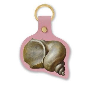 A gold ring keyring with a leather insert showing a shell.