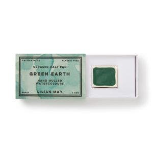 A open box of watercolour green earth pigment paint.