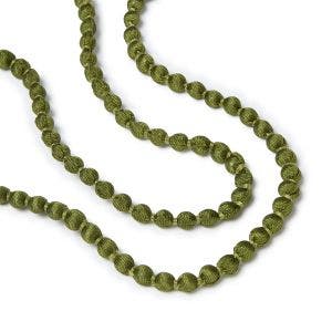 Close up of dark green beads on a necklace.