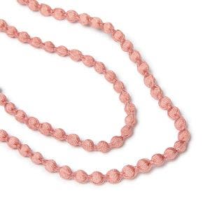 Close up of dusty pink beads on a necklace.