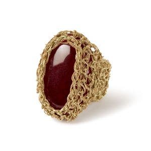 A side view of a gold ring with a large red stone.