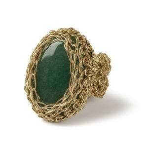 A side view of a large oval green aventurine stone set in a gold wire mesh ring.