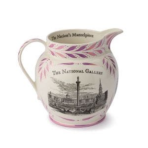 A large ceramic jug featuring the phrase "The Nation's Mantelpiece" painted along the inner rim. The exterior displays a vintage-style black and white illustration of the National Gallery and Trafalgar Square, accented with hand-painted pink leaves.