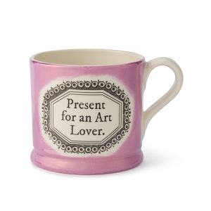 A lustre pink mug with 2 "Present for an Art Lover." written in black in the centre.