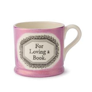 A lustre pink mug with 2 "For Loving a Book." written in black in the centre.