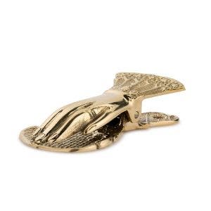 A side view of a gold hand paperclip. The hand has a cuff with ornate details.